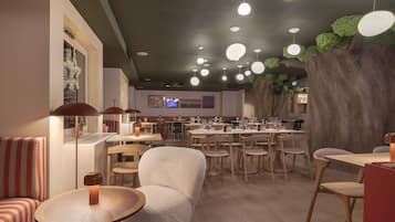 A modern restaurant interior with round tables, cushioned seating, and a ceiling with hanging lights.