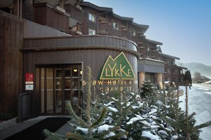 Entrada de un hotel con un letrero que dice 'LYKE Snow Hotel & Spa'.