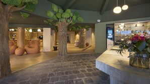 Un hall con suelo de piedra, una recepción y una exhibición de flores.