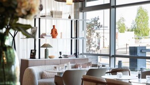Un intérieur moderne avec un canapé, des fauteuils, une table à manger et une bibliothèque.