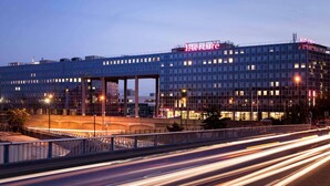 Un hôtel moderne, reconnaissable à son grand panneau « Mercure », à ses larges fenêtres et au pont qui se trouve au premier plan.