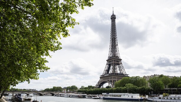 Une vue de la Tour Eiffel avec des bateaux amarrés le long de la rive.