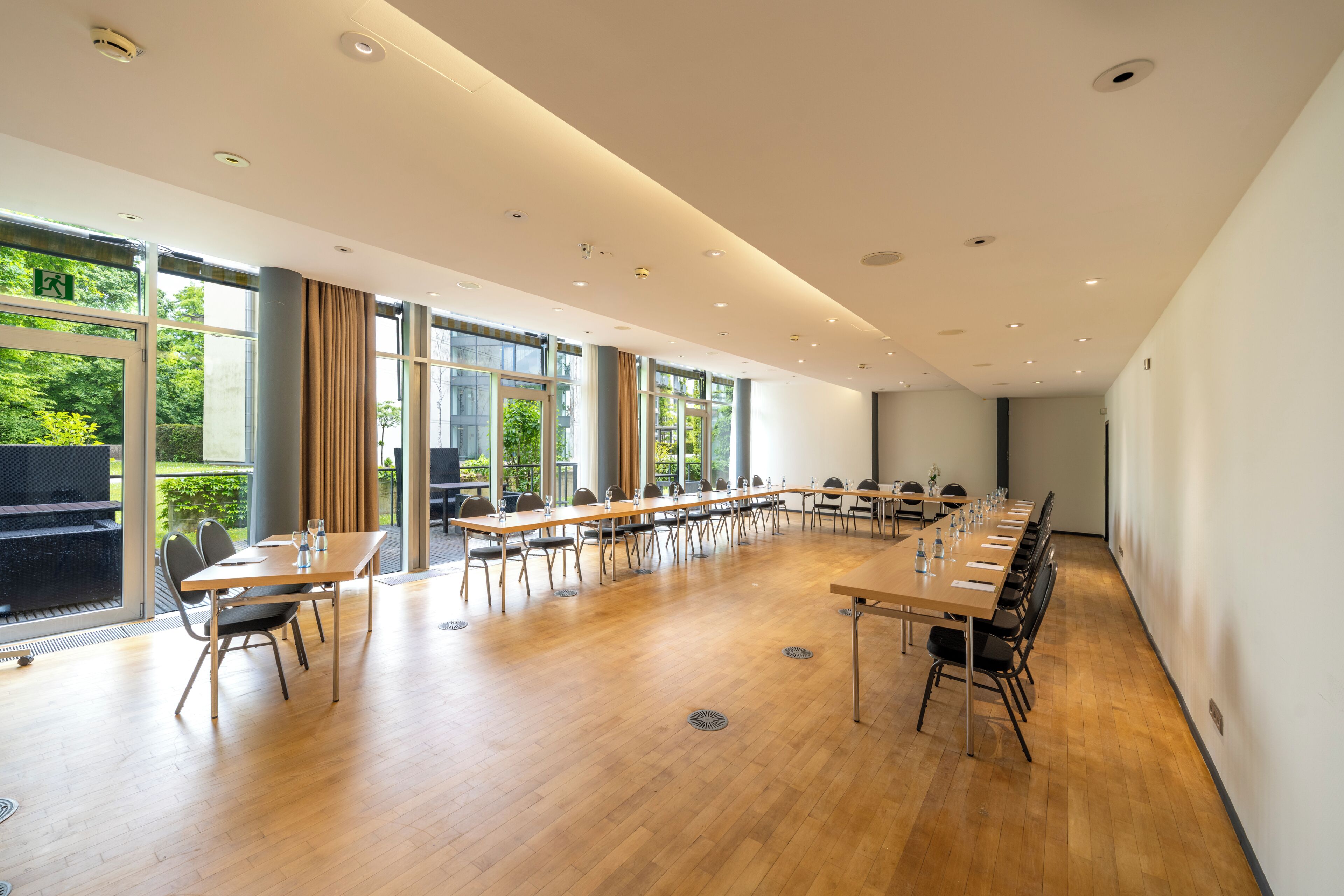 A conference room with a long table, chairs, and large windows.