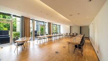 A conference room with a long table, chairs, and large windows.