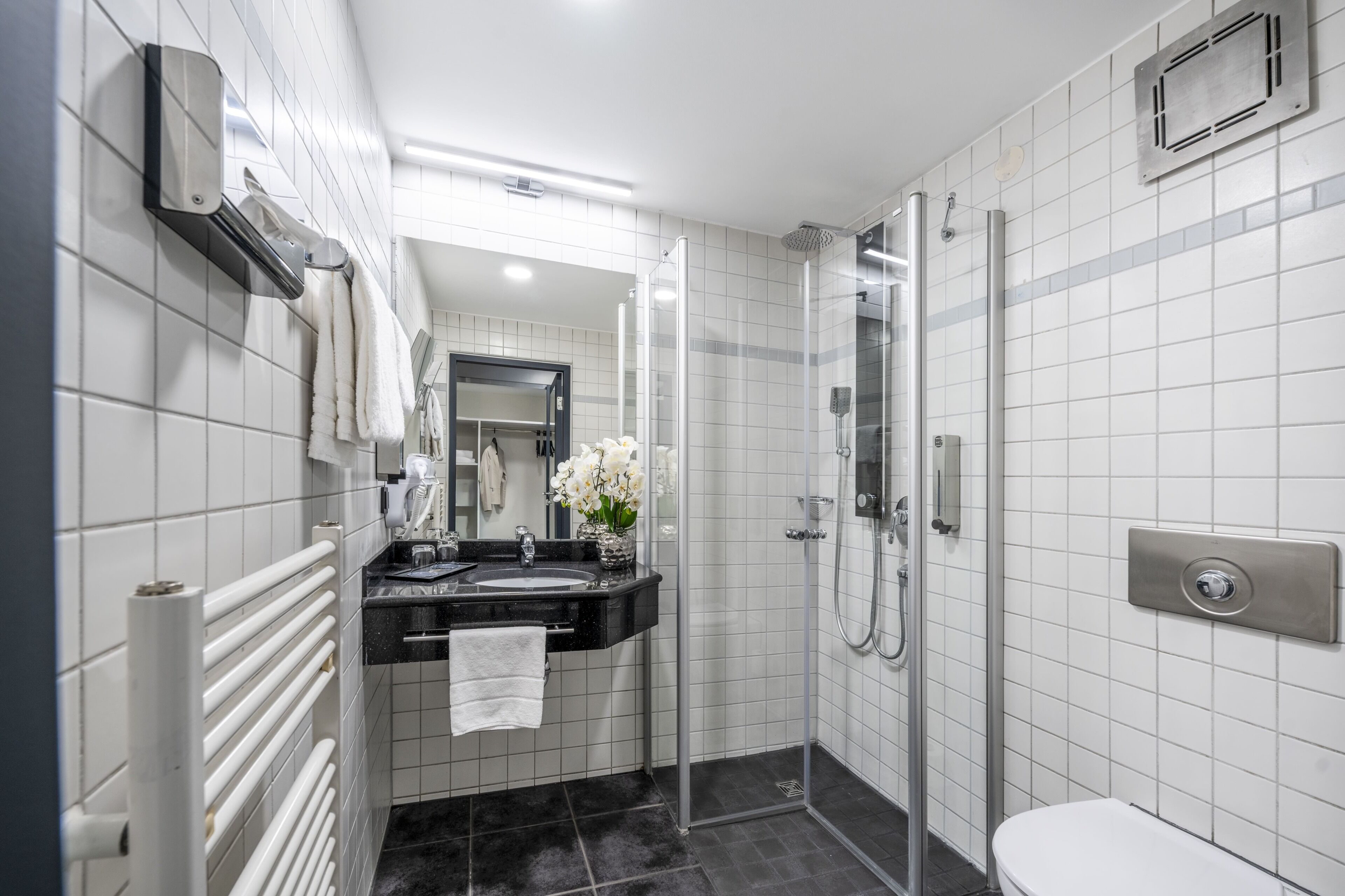 A modern bathroom with a shower, toilet, and sink.