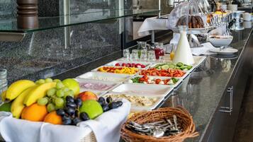 Un bufé con diversas opciones de comida y bebidas.