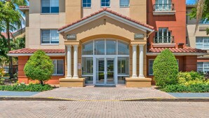 A hotel entrance with a double door, columns, and a sign above the door.