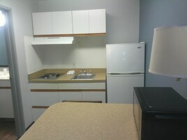 Una kitchenette compacta con un lavamanos, estufa y refrigerador.