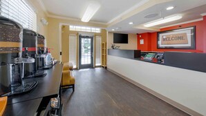 A reception area with a coffee station, a seating area, and a 'WELCOME' sign on the wall.