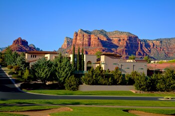 A golf course with a large building in the background. at Hilton Sedona Resort at Bell Rock