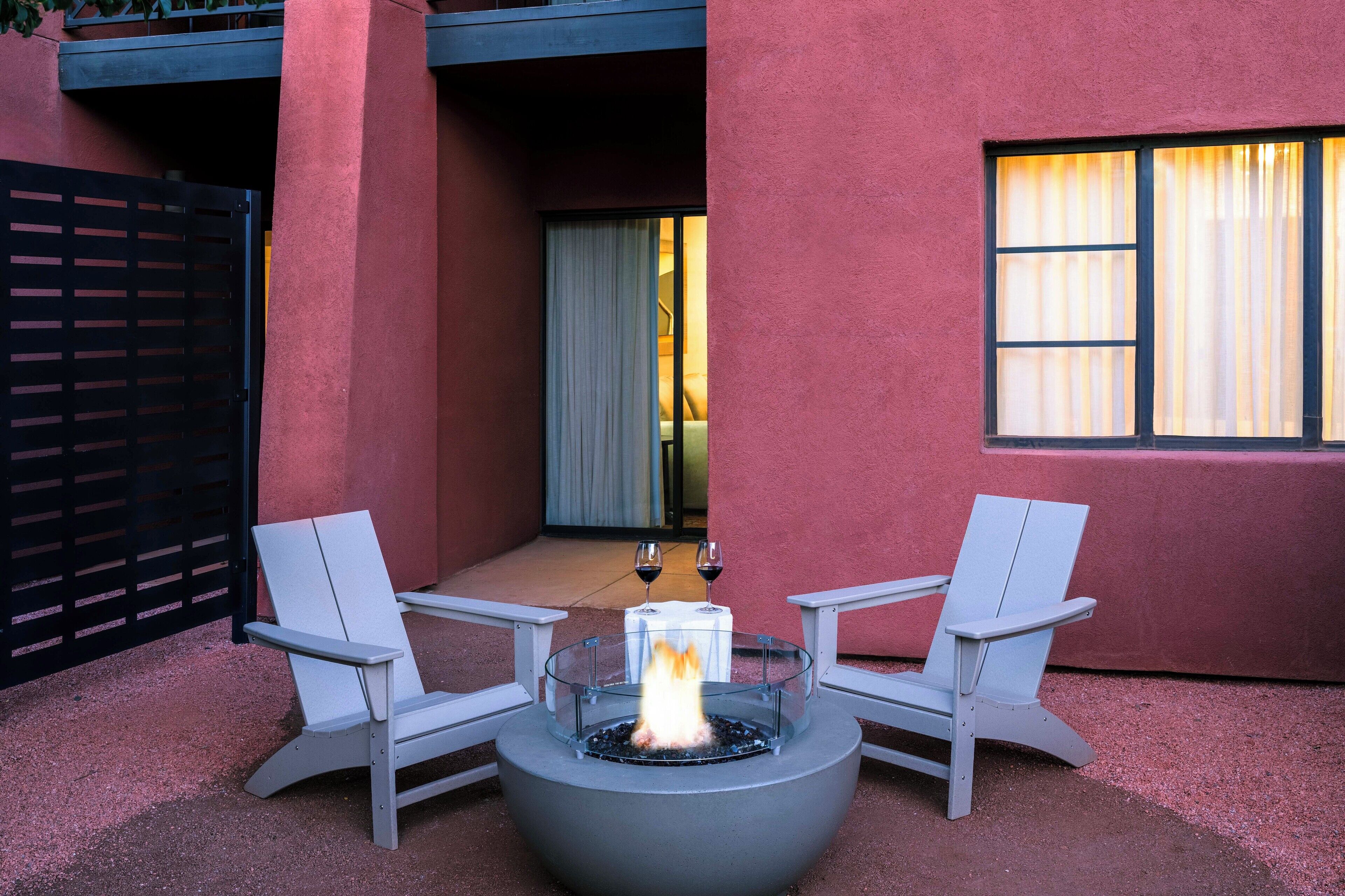 An outdoor seating area with two chairs and a fire pit.