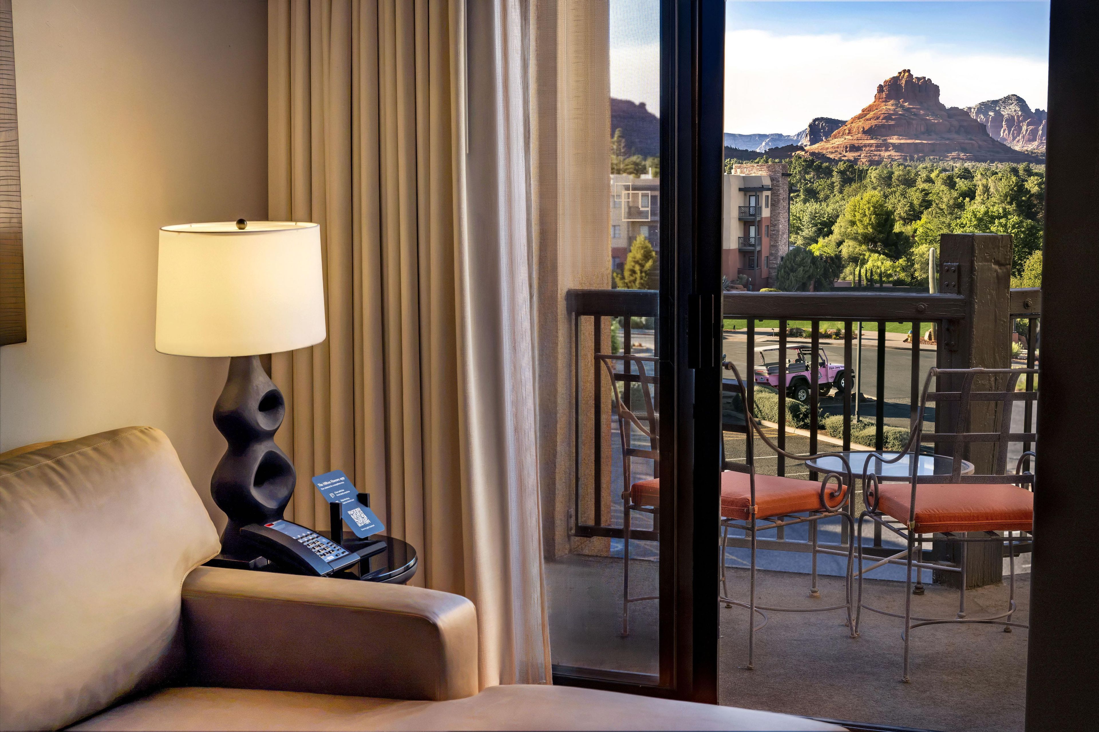 A hotel room with a view of a mountainous landscape.