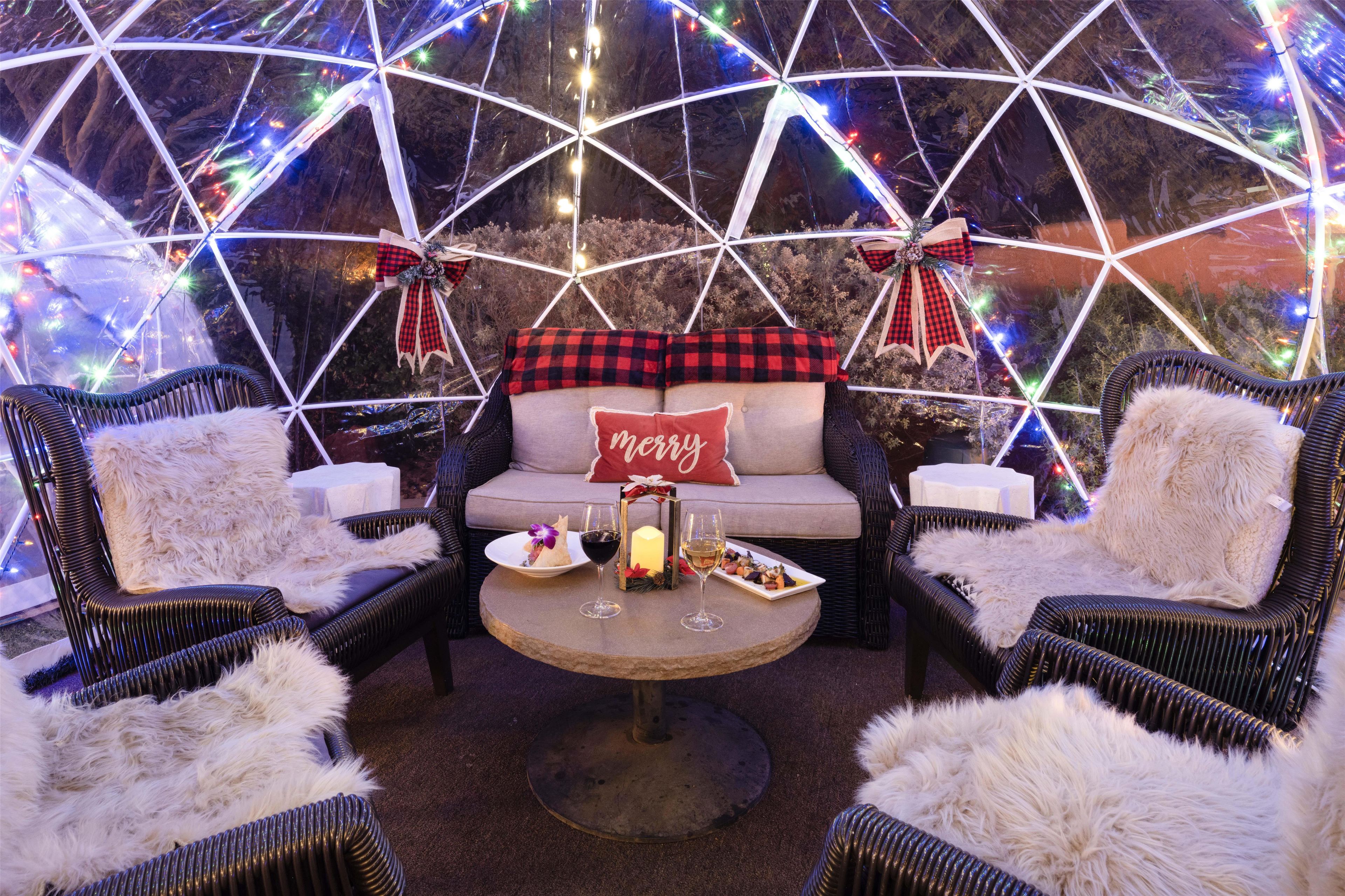 A cozy seating area with wicker chairs, a round table, and a couch adorned with festive decorations.