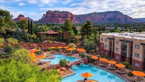 A resort with a swimming pool, lounge chairs, and umbrellas. - Hilton Sedona Resort at Bell Rock (Sedona)
