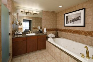 A modern bathroom with a large bathtub, a vanity with a sink, and a mirror.