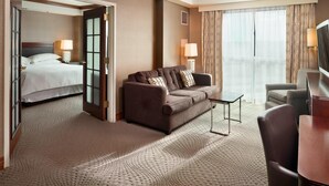 A hotel room with a bed, a sofa, a TV, and a desk.