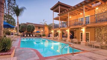 Een buitenzwembad, ligstoelen bij het zwembad