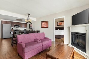 A modern living room with a pink sofa, wooden coffee table, and a fireplace. - Bluegreen Vacations Suites at Hershey, an Ascend Collection Resort (Hershey)