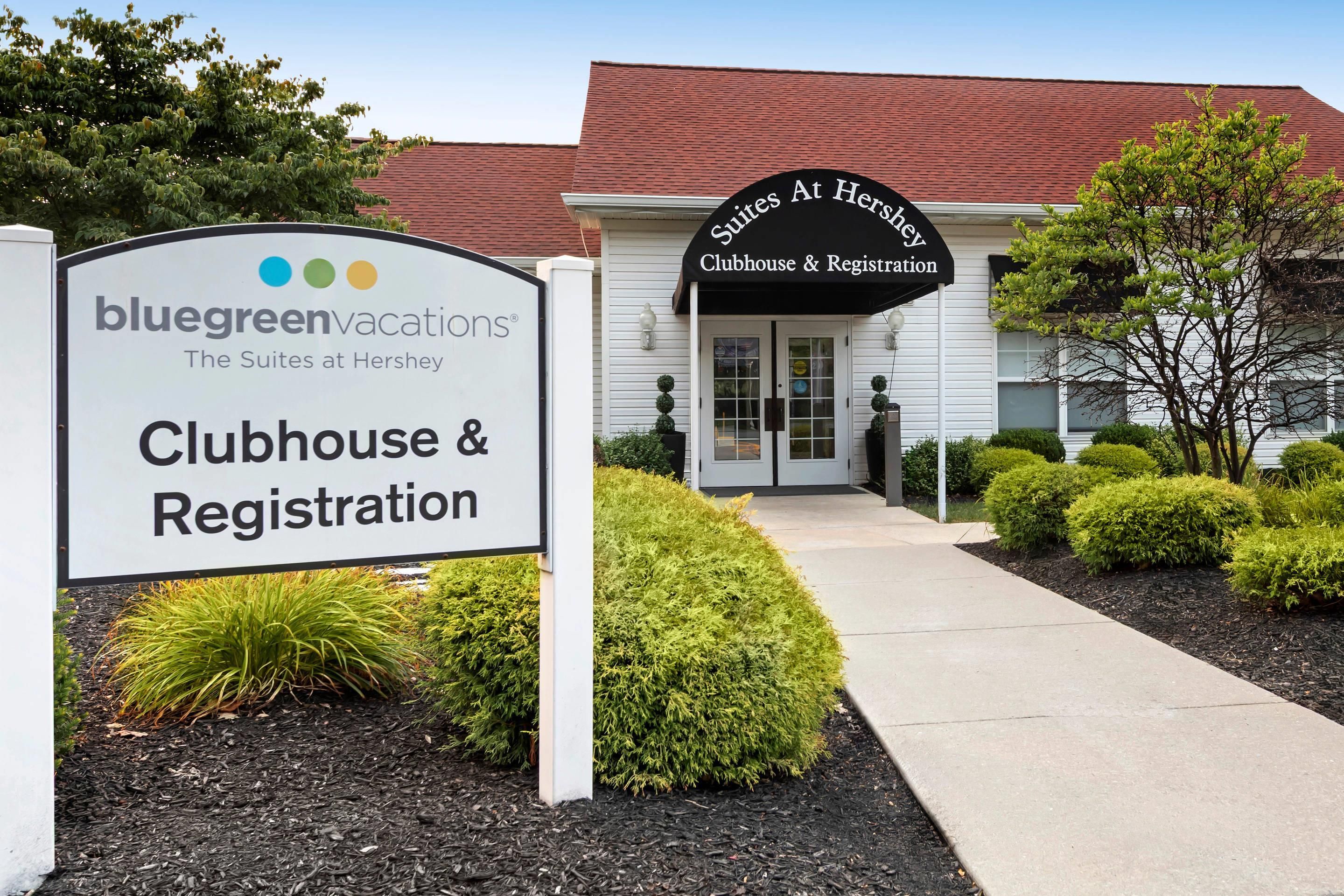 Ein Gebäude mit einem Schild für 'bluegreen vacations' und 'The Suites at Hershey Clubhouse & Registration'.