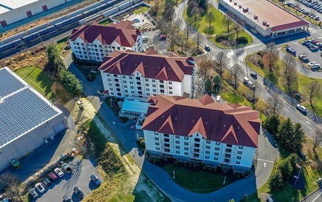 A multi-story hotel with a red roof, surrounded by parking lots and roads.