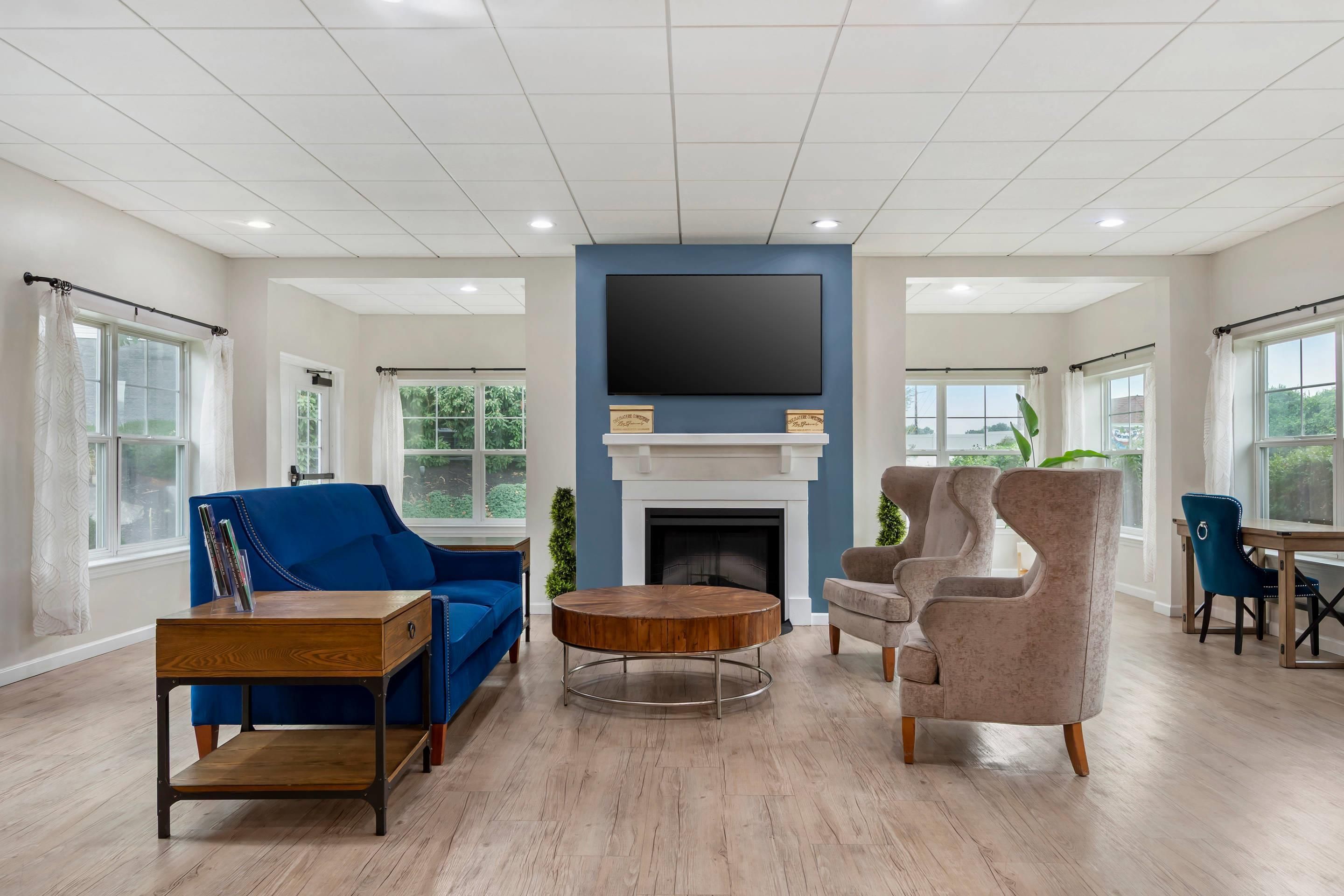 A spacious living room with a fireplace, a flat-screen TV, and modern furniture.