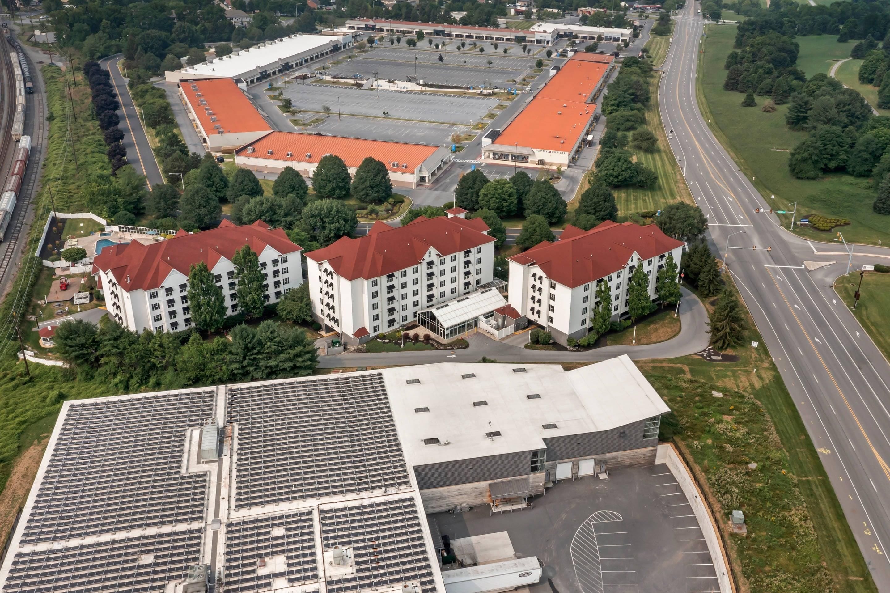 A multi-story building with a parking lot and a road nearby.