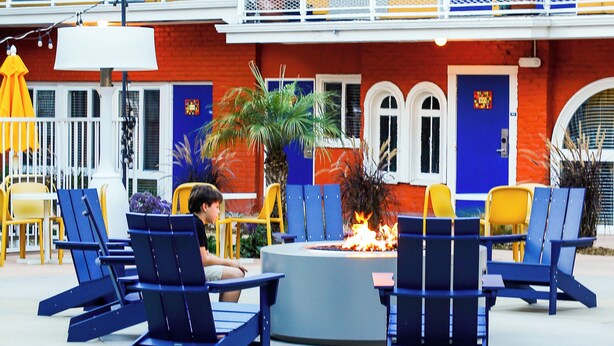 Outdoor seating with blue chairs and a central fire pit. - Hotel Del Sol (San Francisco)