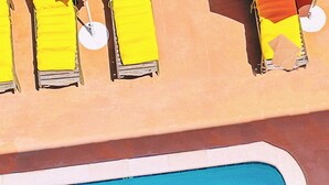 A pool area with yellow and orange sun loungers and a blue pool. - Hotel Del Sol (San Francisco)