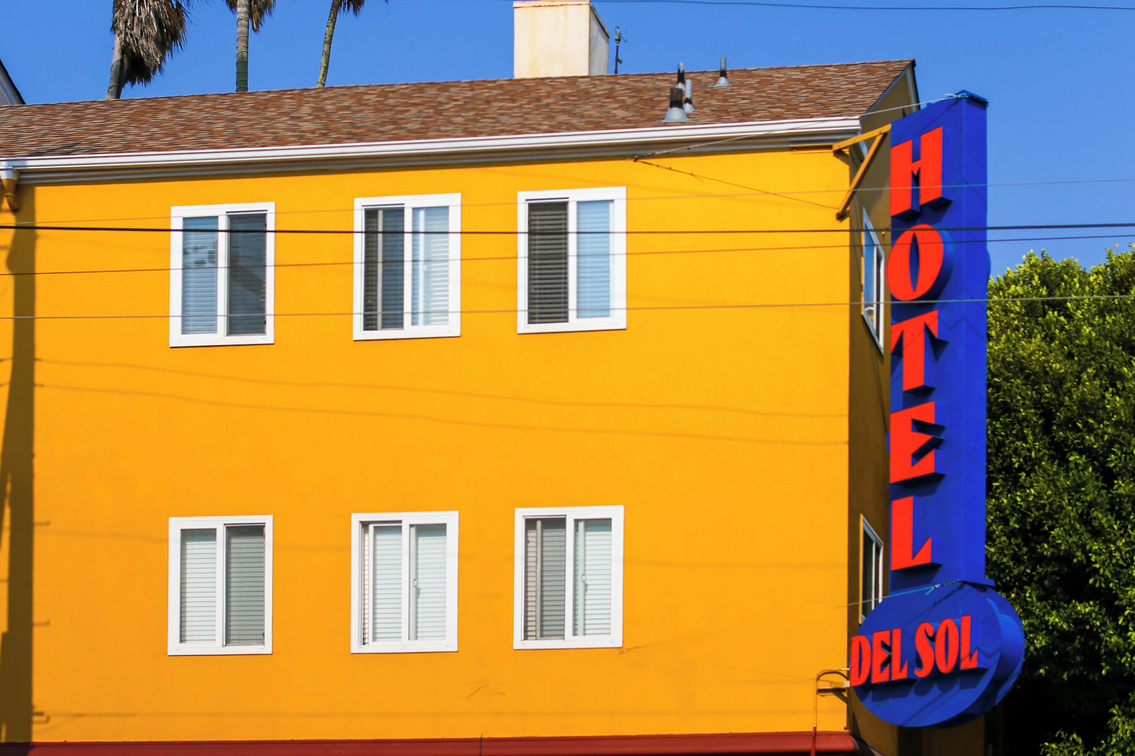 A yellow building with a sign that reads "HOTEL DEL SOL."