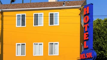 A yellow building with a sign that reads "HOTEL DEL SOL."