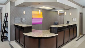 A reception area with a curved counter, a painting on the wall, and a notice board. - Residence Inn by Marriott Richmond Northwest (Richmond)