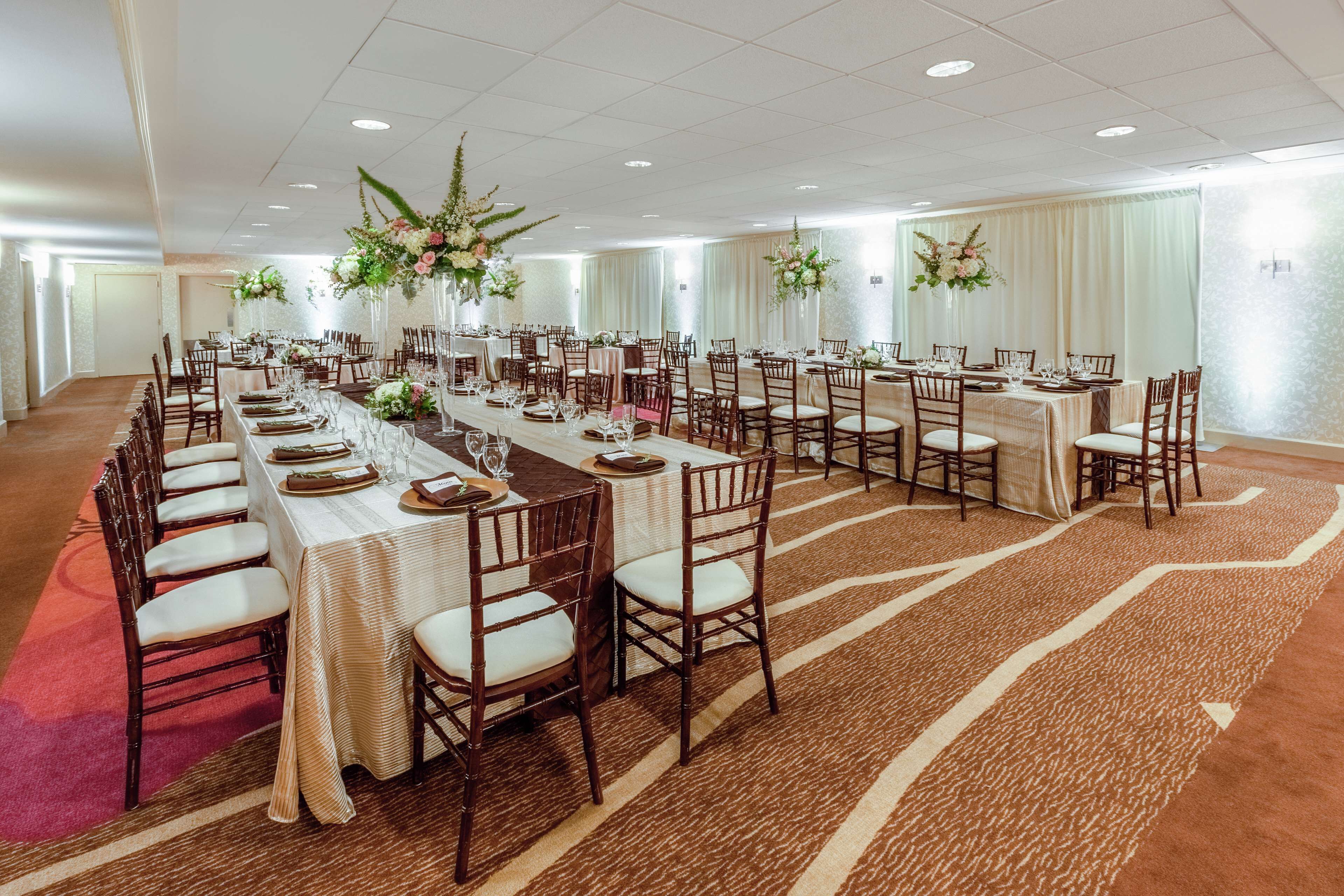 Un salón de banquetes con largas mesas dispuestas para comer, rodeado de sillas.