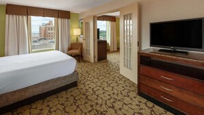 Une chambre d’hôtel avec un lit, une télévision, un bureau et une chaise.