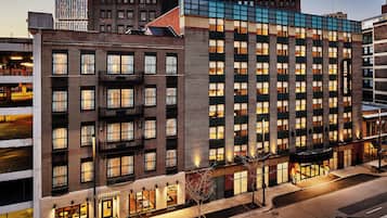 A multi-story hotel with a brick facade, large windows, and a flat roof.