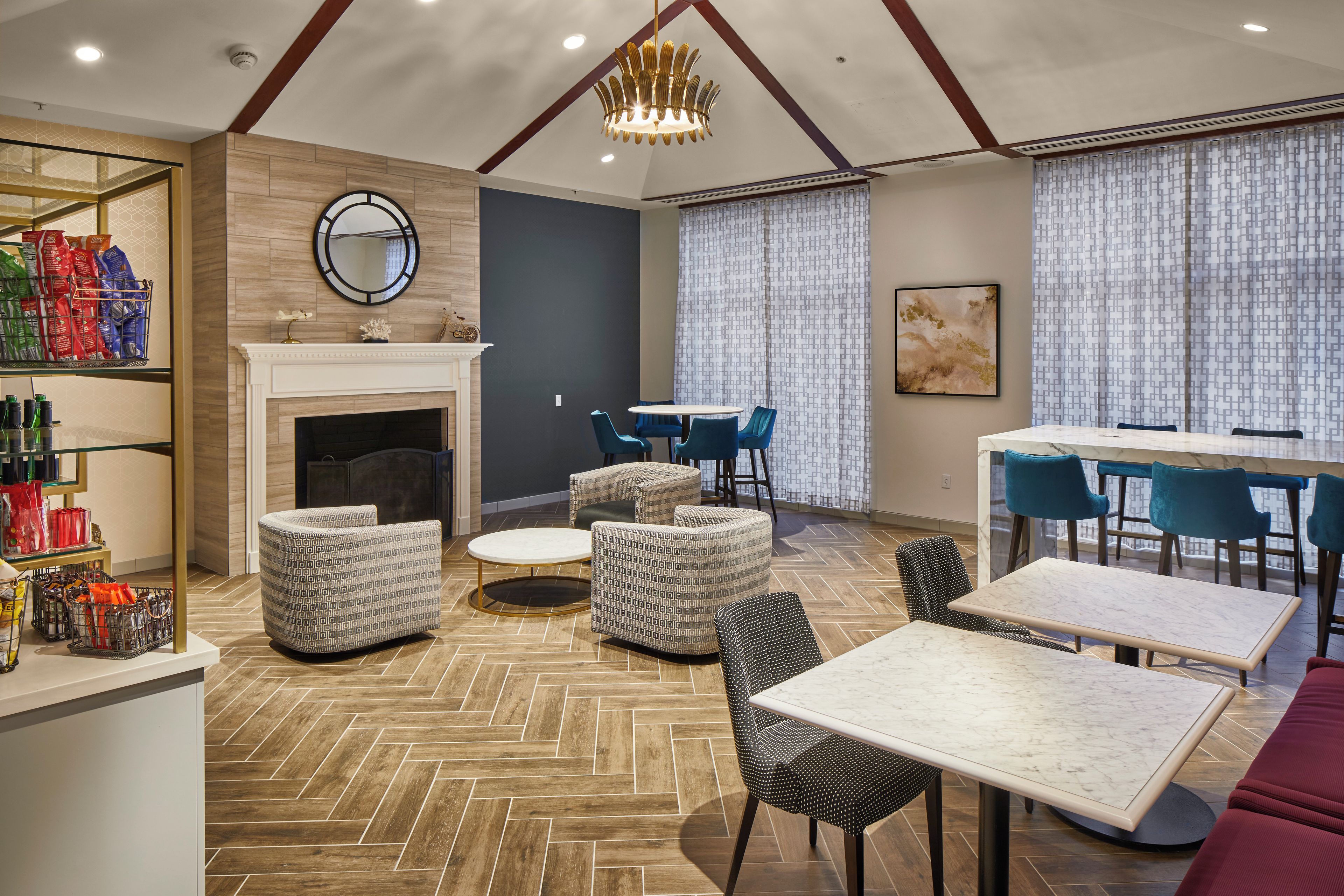 A modern dining area with a fireplace, patterned sofas, and a marble table.