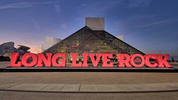 Une grande enseigne lumineuse affichant le message « VIVE LE ROCK » devant un bâtiment moderne à la façade en verre.