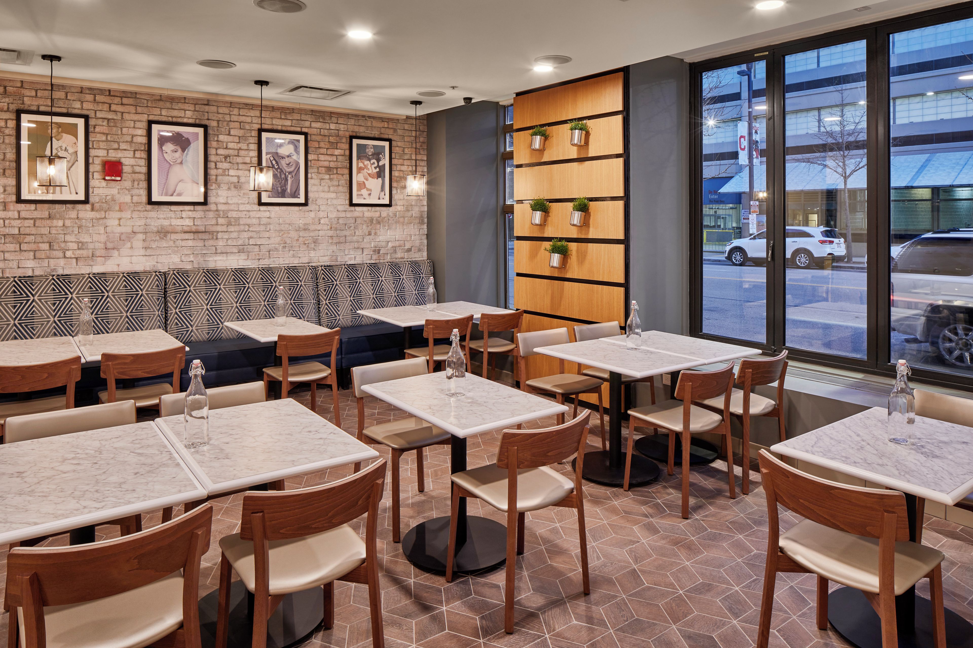 Ein Restaurantinneres mit Backsteinwänden, gerahmten Bildern und Blick auf die Straße.