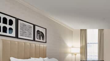 A hotel room with two beds, a bedside table, a lamp, and a window with curtains.