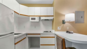A compact kitchenette with a microwave, stove, and a small sink.