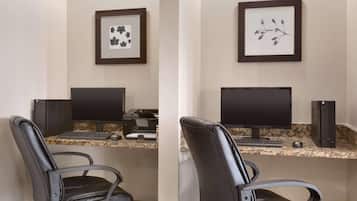 A workspace with a desk, two monitors, a keyboard, a mouse, a printer, and a chair.