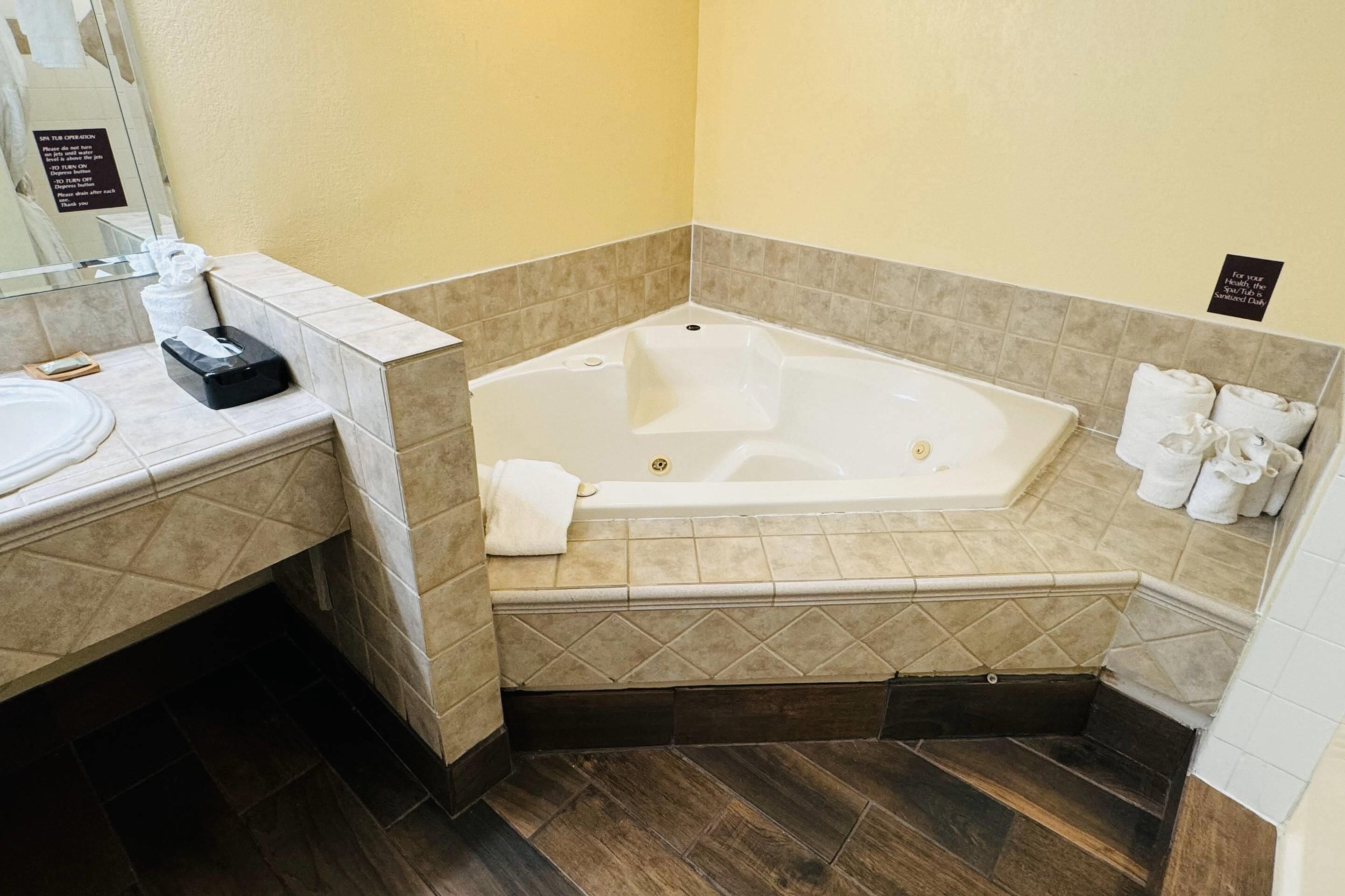 A bathroom with a bathtub, a sink, a towel rack, and a hand dryer.