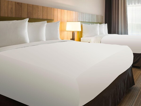 A hotel room with two beds, a wooden headboard, a bedside lamp, and a window with curtains. - Country Inn & Suites by Radisson, Mishawaka, IN (Mishawaka)