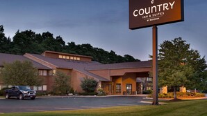 Un bâtiment Country Inn & Suites by Radisson avec un parking et un camion garé devant.