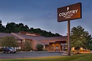 A Country Inn & Suites by Radisson building with a parking lot and a truck in front. - Country Inn & Suites by Radisson, Mishawaka - South Bend (Mishawaka)