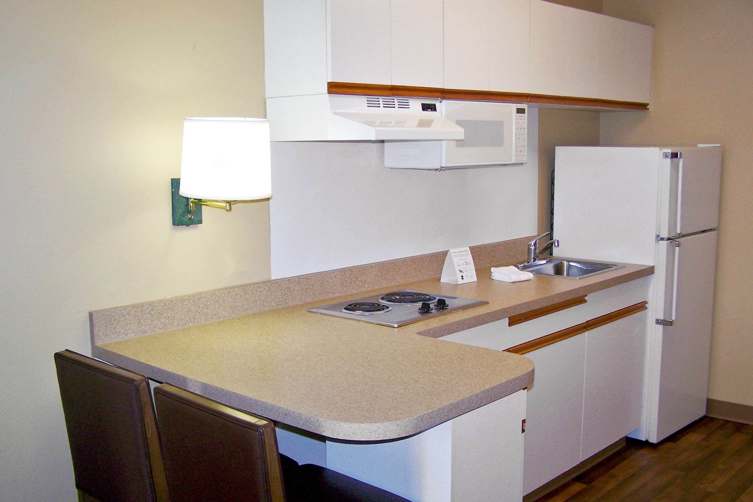 Cocina compacta con microondas, estufa, fregadero y refrigerador.