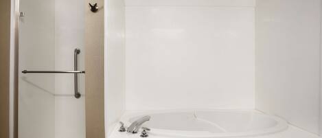 Ein Badezimmer mit bodengleicher Dusche, einer Badewanne und einem WC.