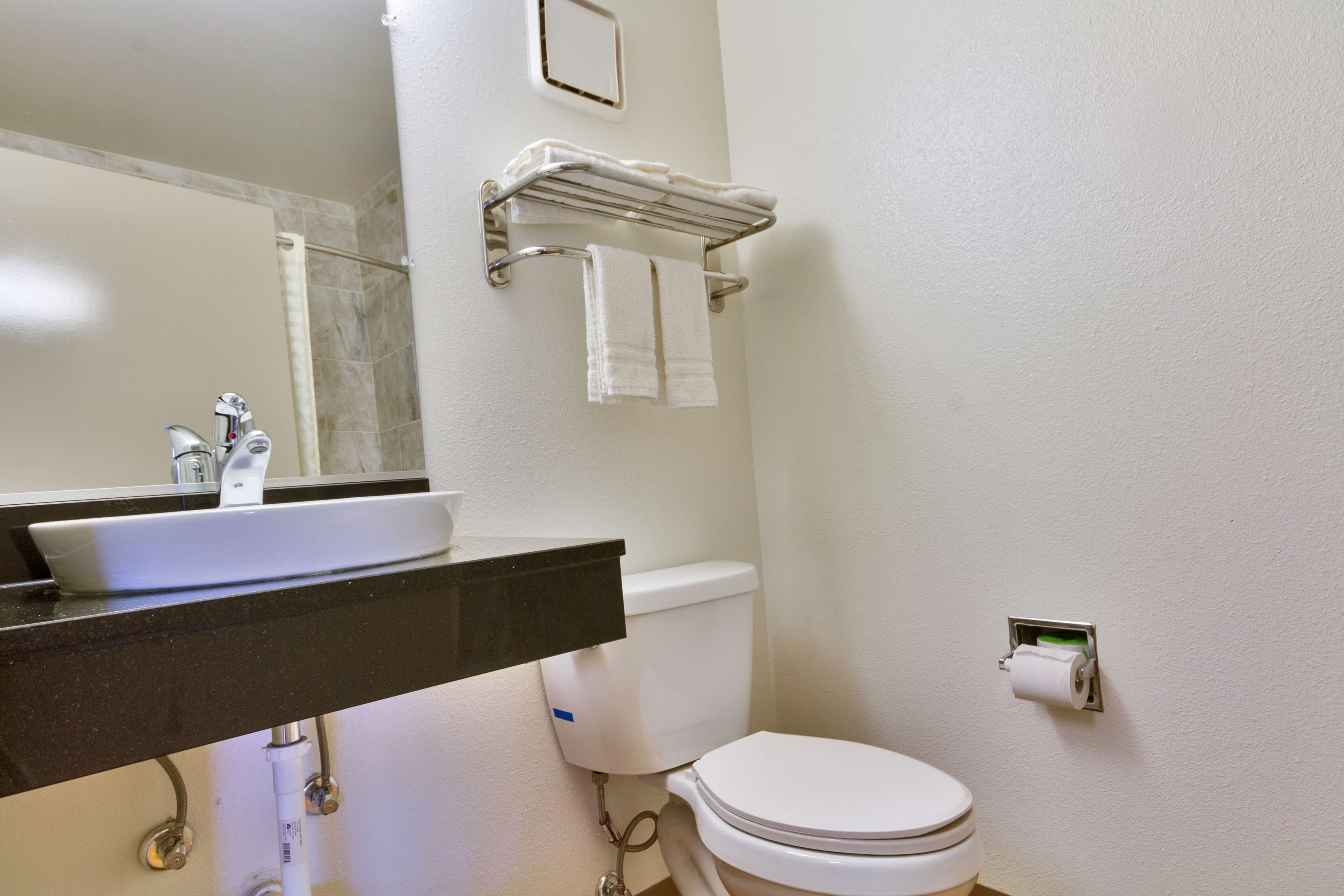 A bathroom with a sink, toilet, and towel rack.