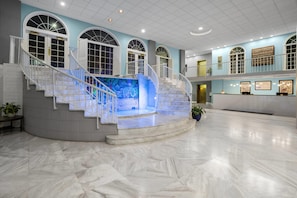 A spacious lobby with a marble floor, a central staircase, and arched windows. - Coconut Malorie Resort Ocean City, an Ascend Collection Hotel (Ocean City)