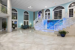 A spacious lobby with a marble floor, a central staircase, and arched windows. - Coconut Malorie Resort Ocean City, an Ascend Collection Hotel (Ocean City)
