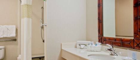 A bathroom with a shower, toilet, and sink.